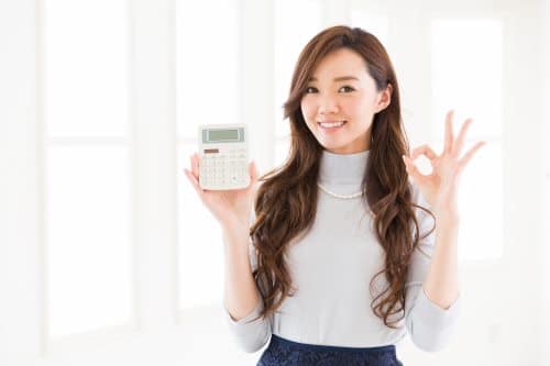 Woman holding a calculator and making an ok sign