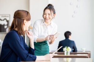 Woman ordering from staff at a cafe