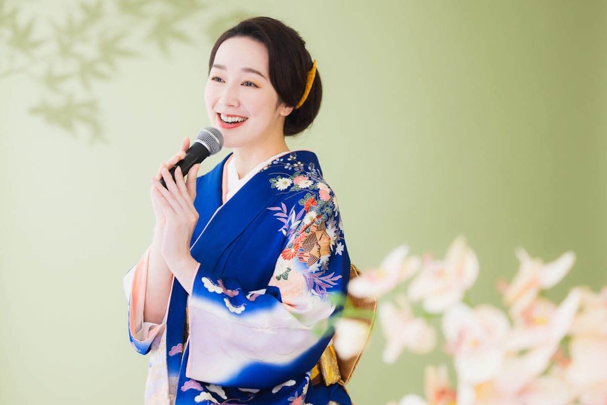 Woman in a blue kimono singing