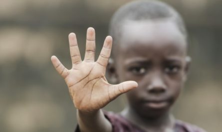 Boy holding up hand to say stop
