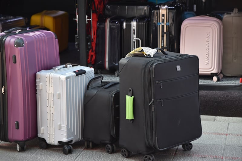 Bunch of suitcases being loaded onto what appears to be an airport shuttle