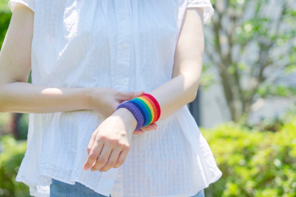 Person wearing an LGBTQ colored wristband