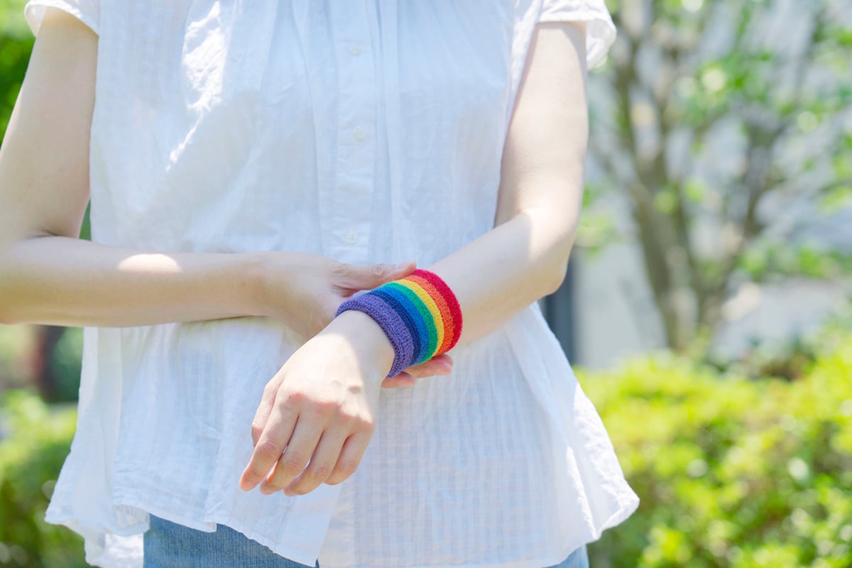 Person wearing an LGBTQ colored wristband