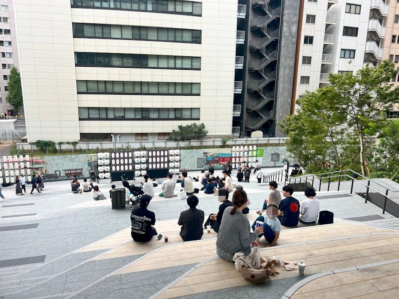 People sitting on steps near NeWoman