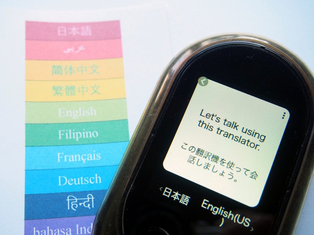 A translation device with the phrase "Let's talk using this translator" translated into Japanese