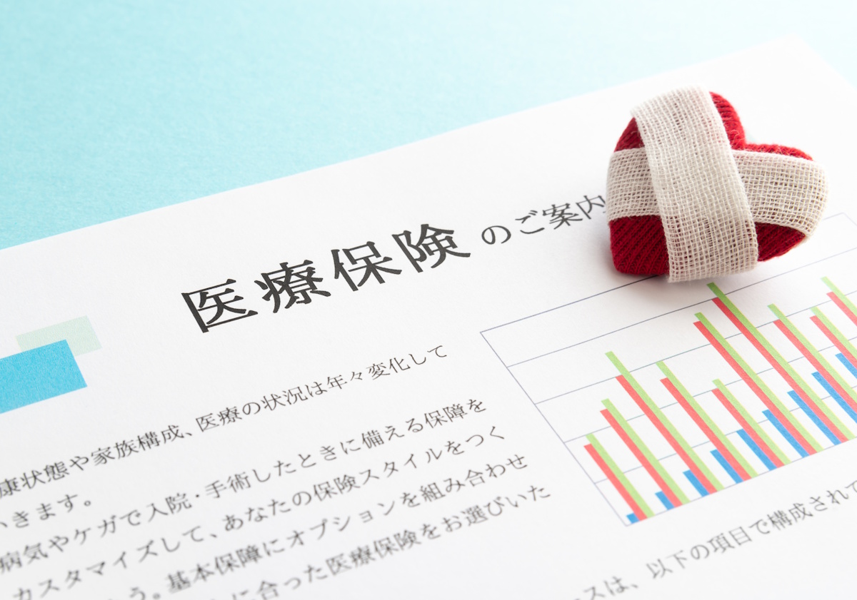 Picture of a bandaged heart on papers detailing health coverage in Japanese