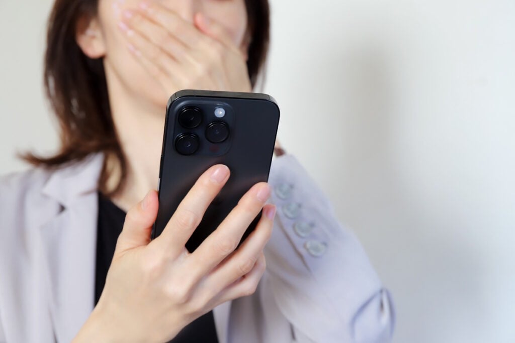 Woman looking in shock and surprise at smartphone