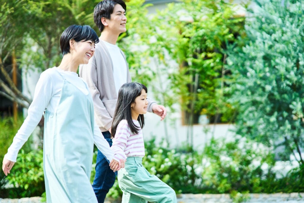 A mom and dad walking hand in hand with their child