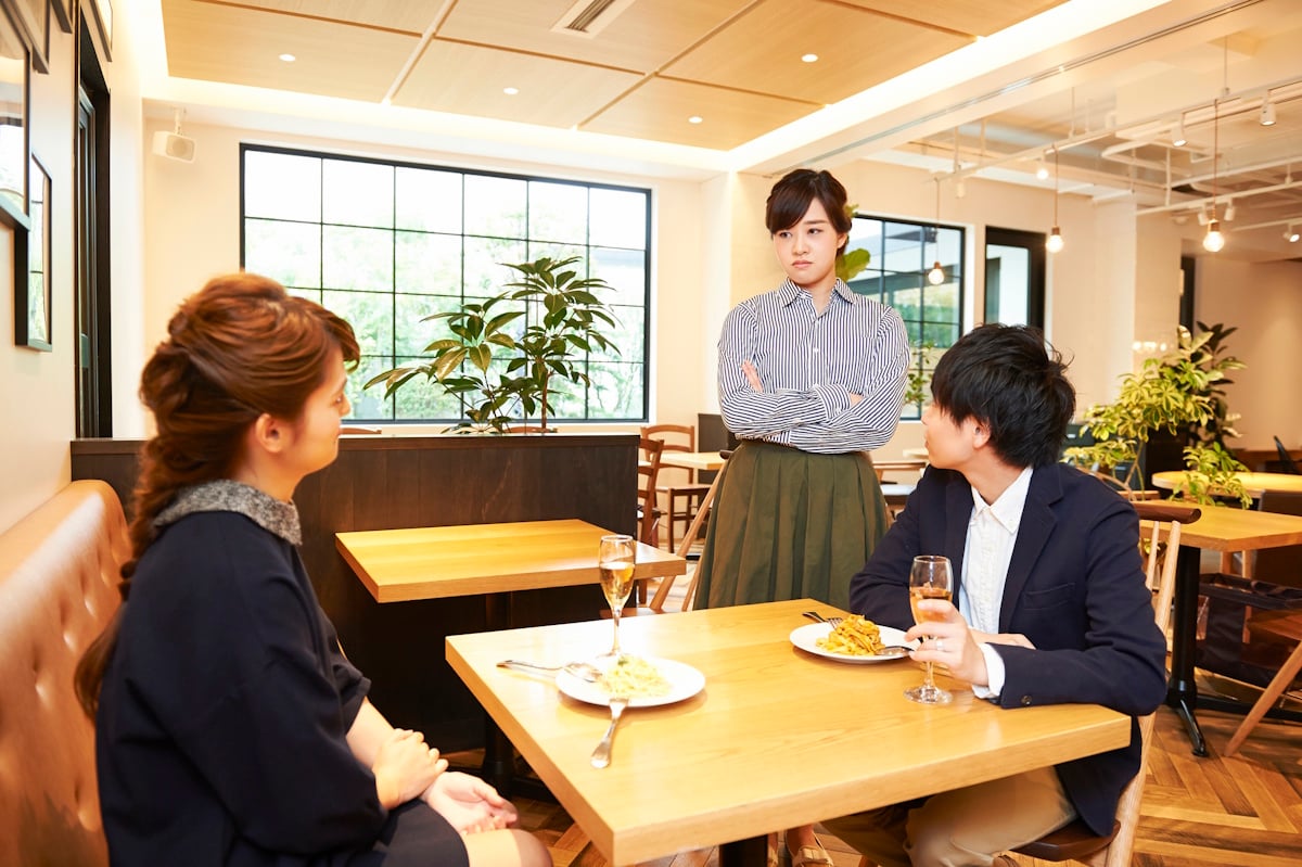 Wife staring down her husband's lover in a cafe