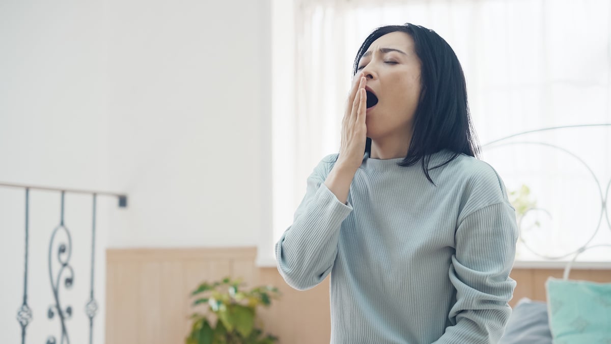 Woman yawning after a bad night's sleep caused by overwork, probably