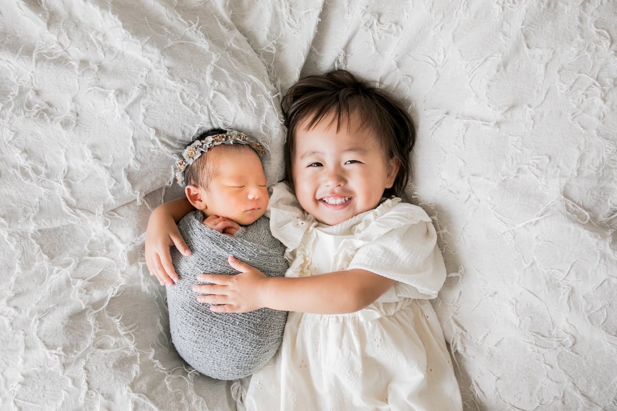 A child holding a baby in bed