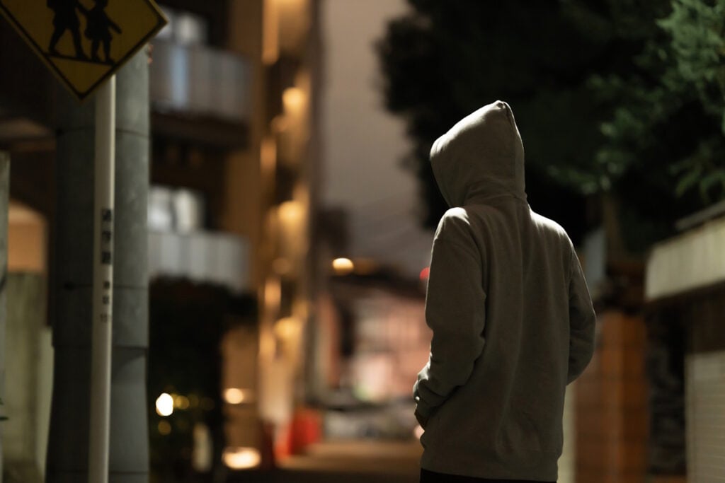 Suspicious man in hoodie on Japanese city street