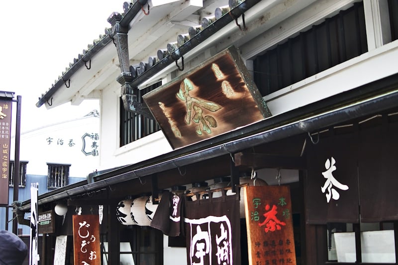Wooden 'cha' (tea) signboard hanging over traditional tea shops on Uji's Omotesando street near Byodoin