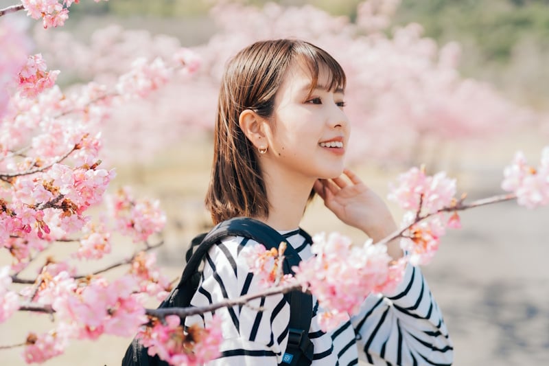 Woman standing near a cherry blossom tree